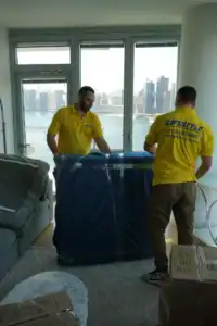 Movers working around a sofa in a high-rise apartment