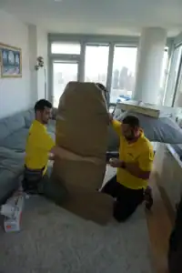 Mover carrying a wrapped item through an apartment