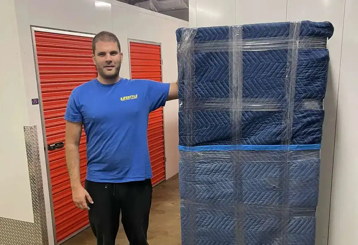 Mover standing beside a wrapped piece of furniture