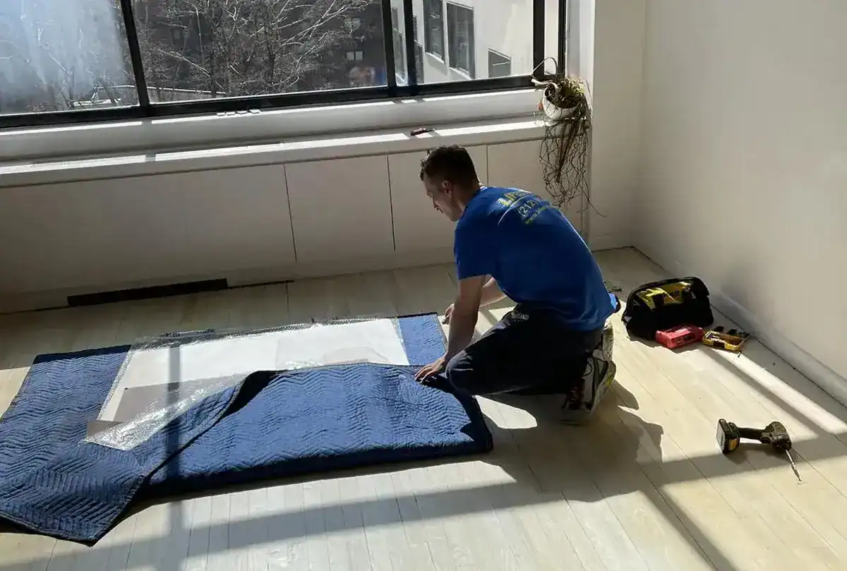 Mover placing protective material on the floor