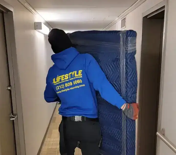 Mover guiding a wrapped item through a doorway