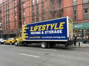 Lifestyle Moving & Storage truck beside a brick apartment building