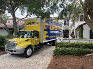 Lifestyle Moving & Storage truck parked outside a palm-lined home