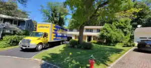 Lifestyle Moving & Storage truck parked outside a modern home